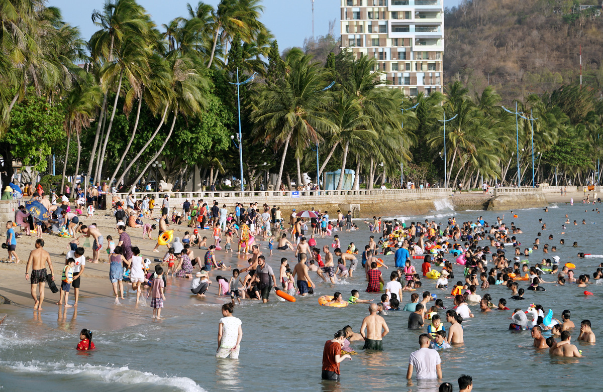 Hình ảnh người dân và du khách nô đùa và hòa lẫn tắm biển Bãi Trước. trong dịp hè